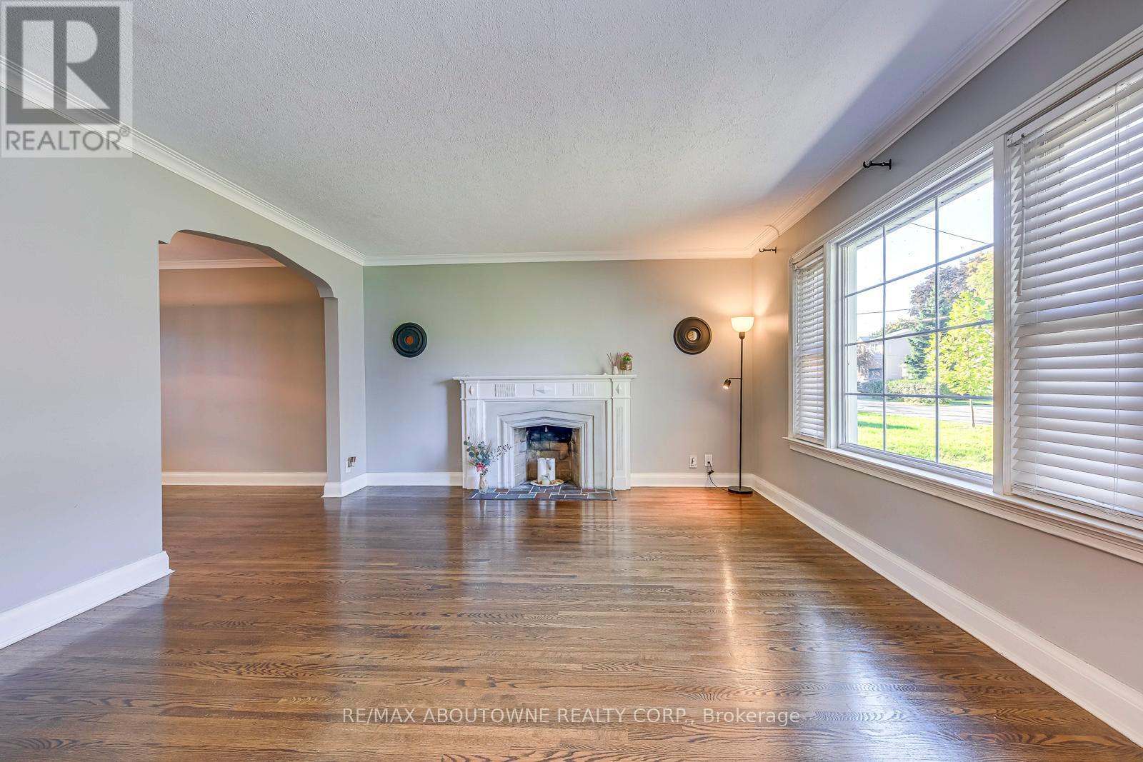 A spacious room with a fireplace and wood flooring.