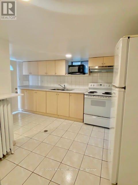 A kitchen with white appliances and a white refrigerator.