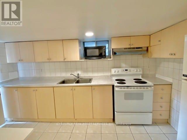 A kitchen with a white stove and cabinets.
