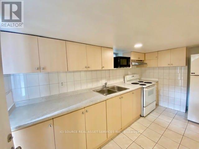 A kitchen with white cabinets and appliances.