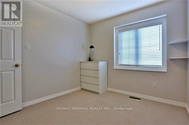 A bedroom with a dresser and a window.