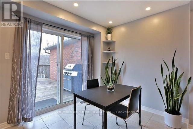 A dining room with a table and chairs and a sliding glass door.