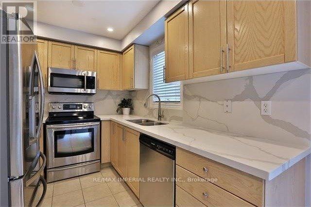 A kitchen with wooden cabinets and stainless steel appliances.