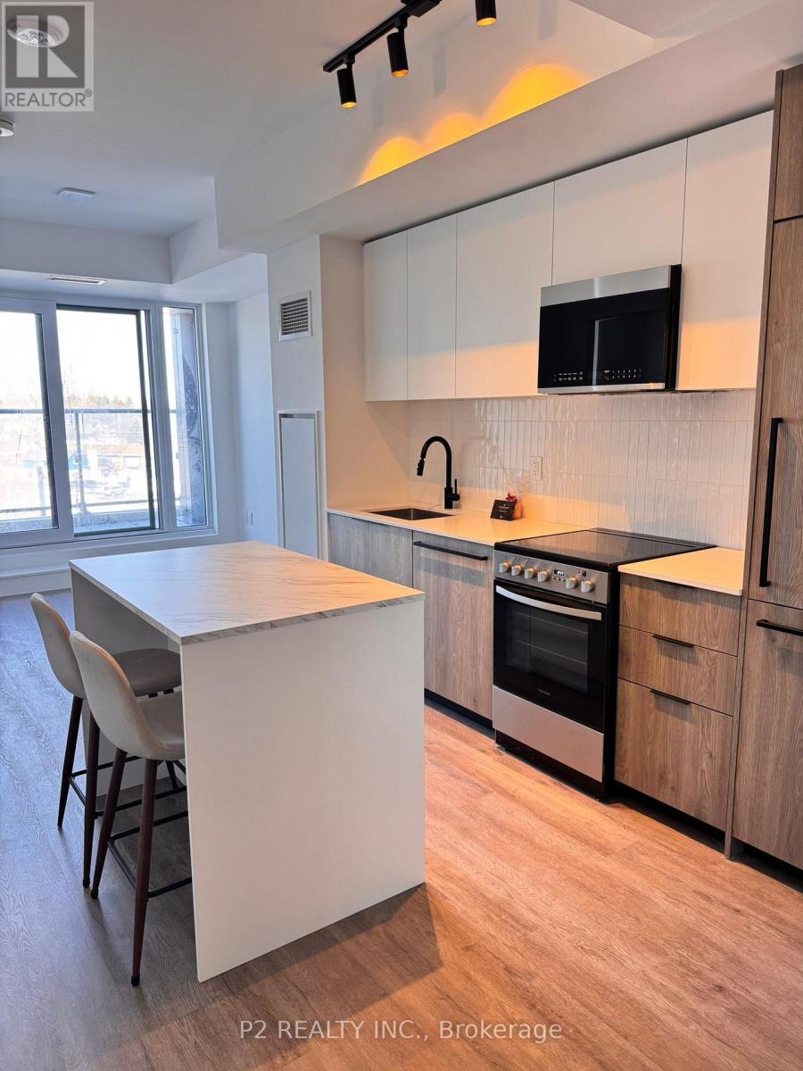 A modern kitchen with wooden cabinets and a flat screen TV mounted above the stove.
