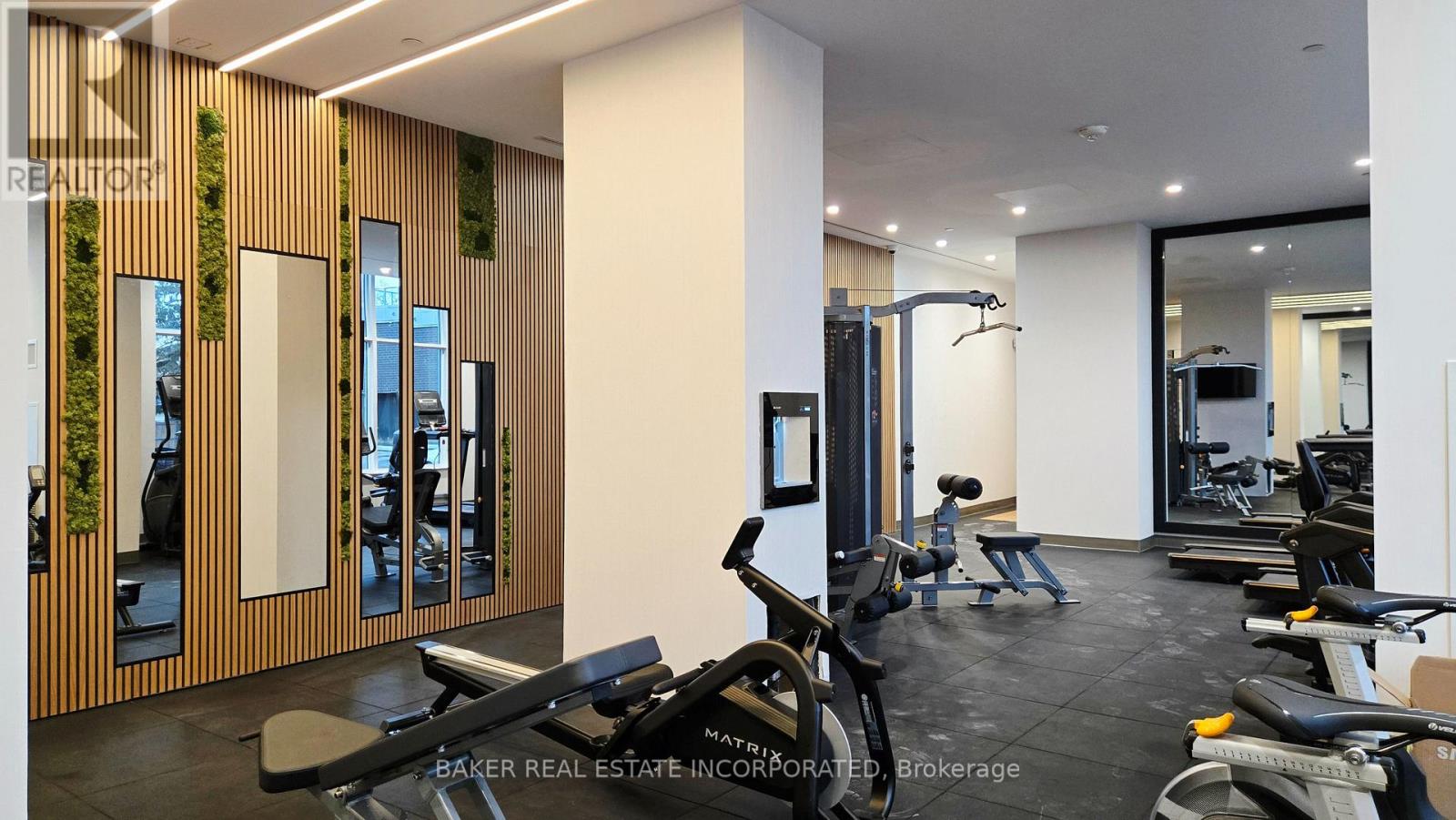 A gym with a row of treadmills and a row of stationary bikes.