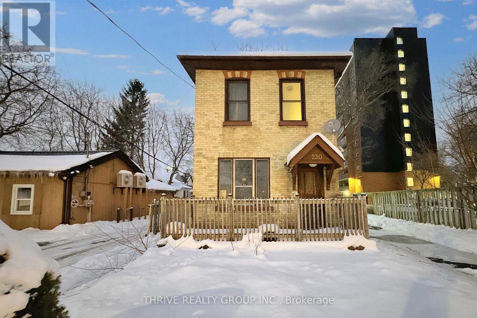 A house with a brown roof and a fence in the snow.