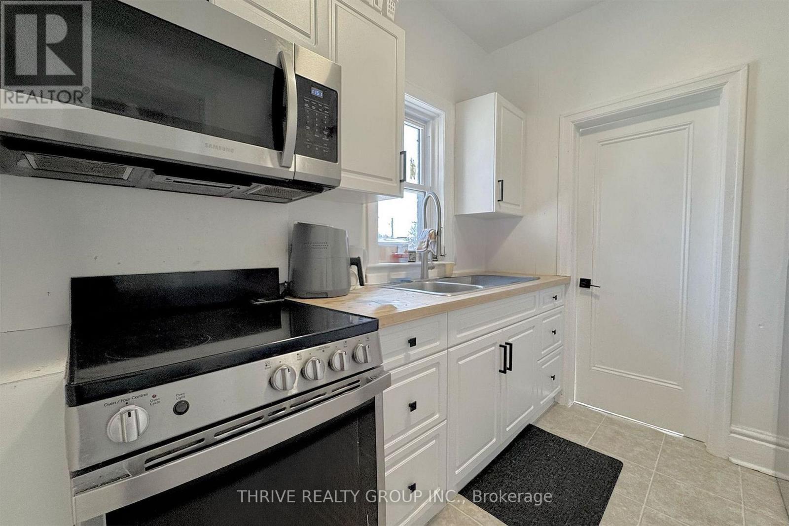 A kitchen with a stove top oven and microwave above it.