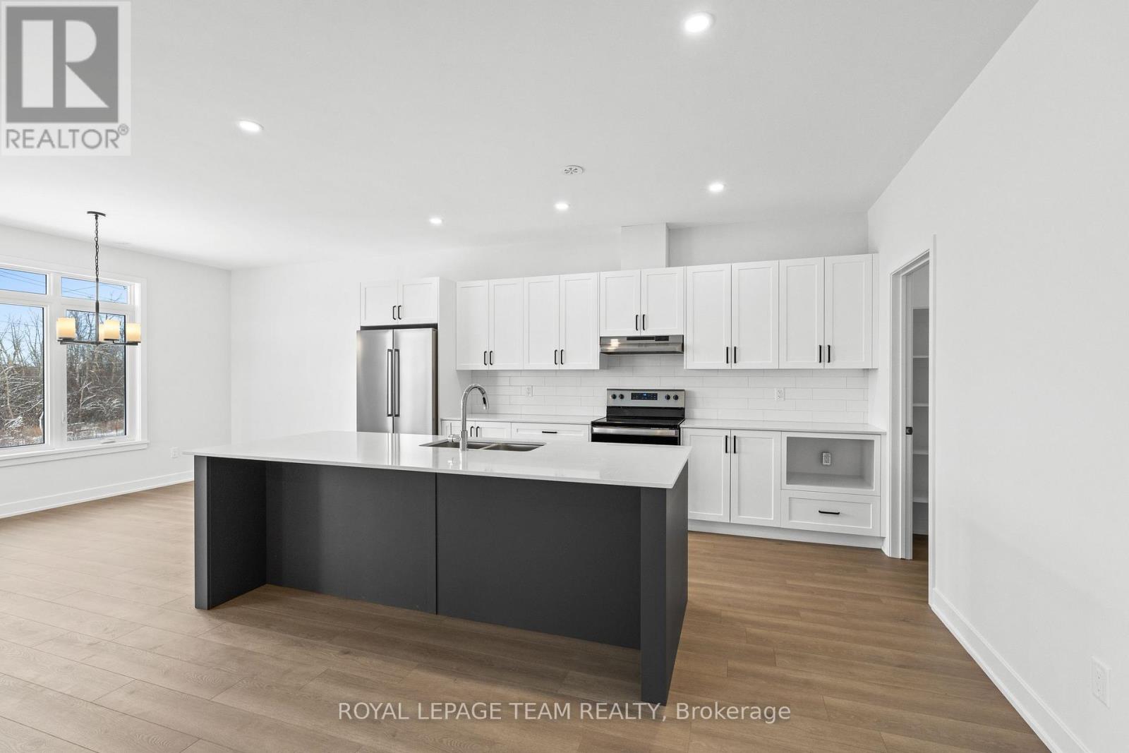 A modern kitchen with white cabinets and a central island.