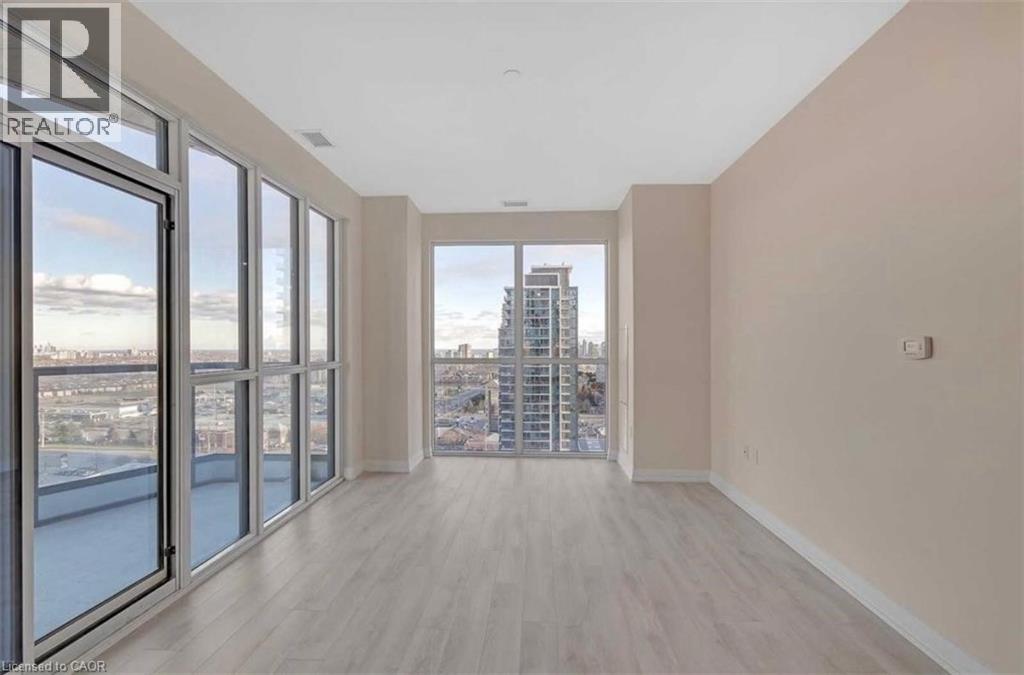 A spacious room with a view of the cityscape through large windows.