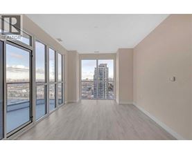 A spacious room with a view of the cityscape through large windows.