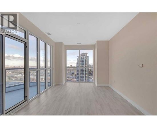A spacious room with a view of the cityscape through large windows.