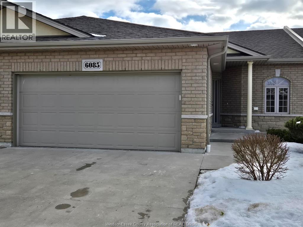 A house with a garage door and a sign that says "6085".