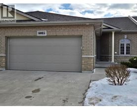 A house with a garage door and a sign that says "6085".