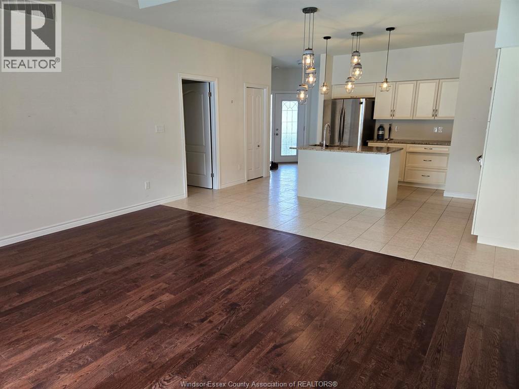 A spacious kitchen with a white island and wooden floors.