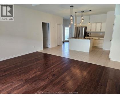 A spacious kitchen with a white island and wooden floors.