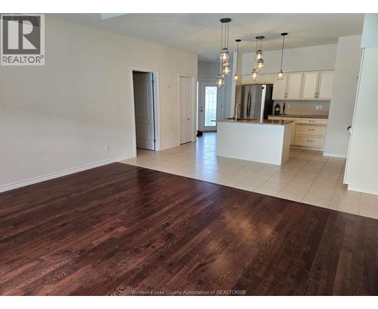 A spacious kitchen with a white island and wooden floors.