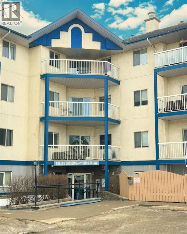 A blue and white apartment building with a sign that says "REALTOR".