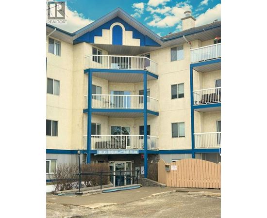 A blue and white apartment building with a sign that says "REALTOR".