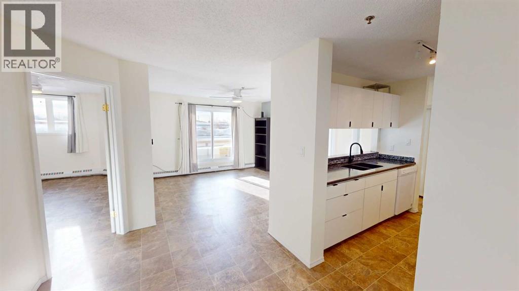 A spacious kitchen with white cabinets and a tiled floor.