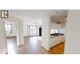 A spacious kitchen with white cabinets and a tiled floor.