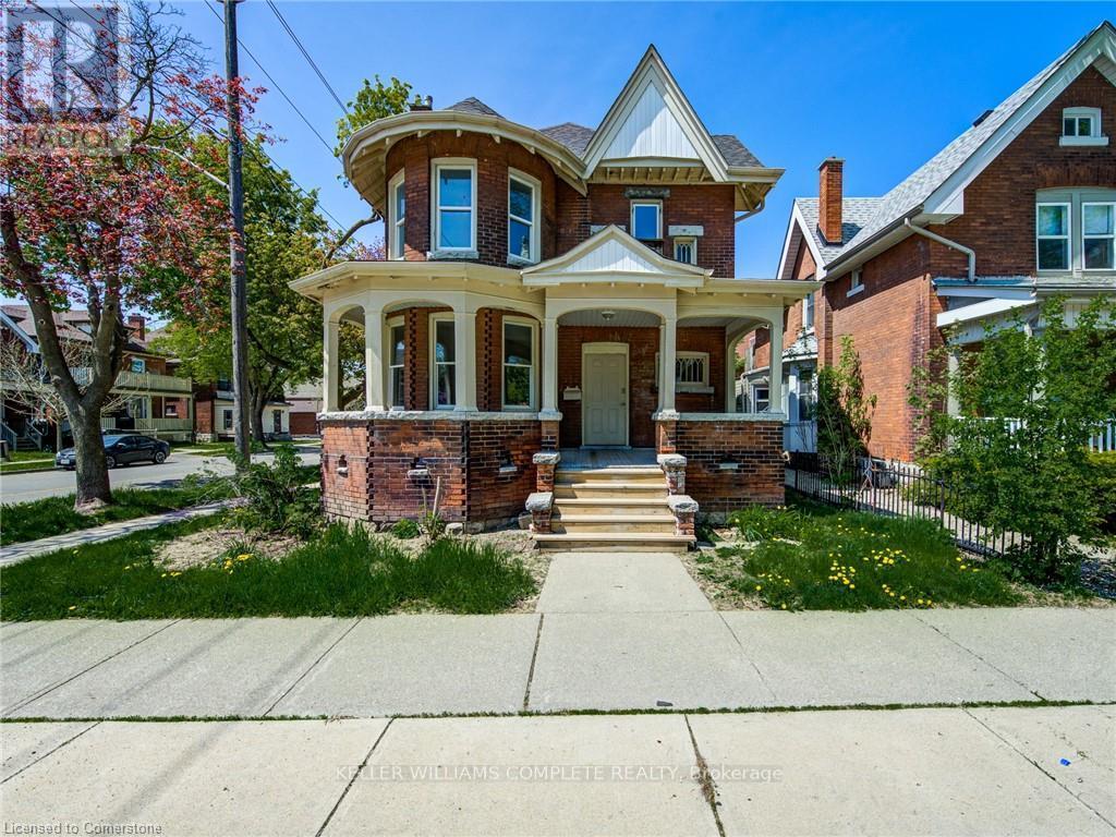A two-story house with a red brick exterior and a white trim.
