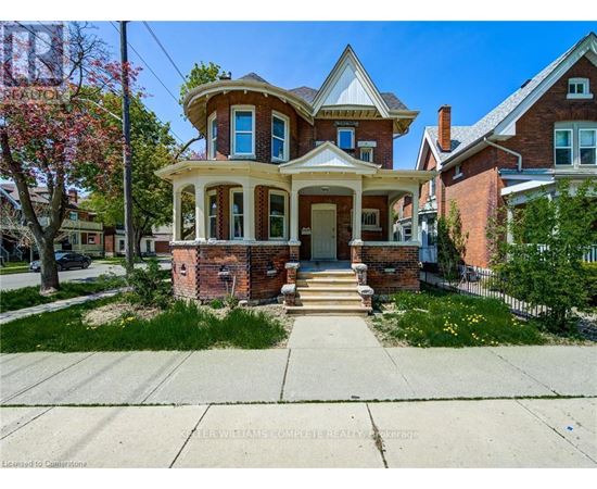 A two-story house with a red brick exterior and a white trim.