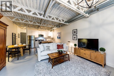 A living room with a white couch and a wooden coffee table.