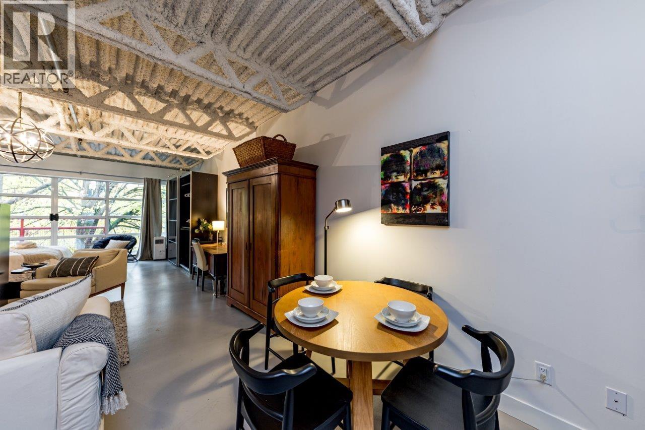 A dining room with a wooden table set for two.