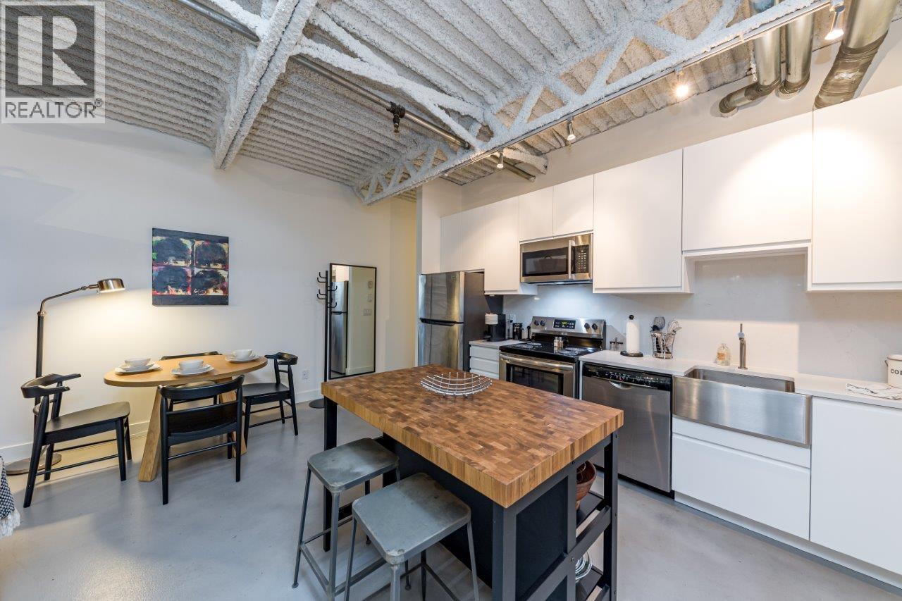 A kitchen with a wooden table and stools.