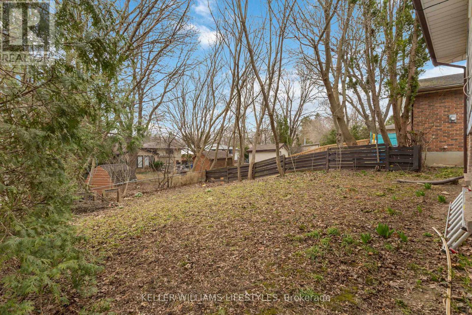 A backyard with a fence and trees.