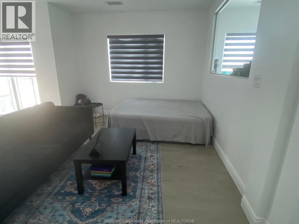 A bedroom with a bed, a couch, and a table.