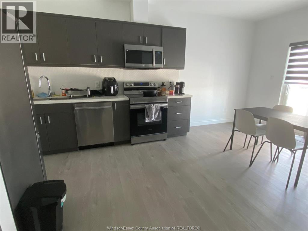 A kitchen with a dining table and chairs.