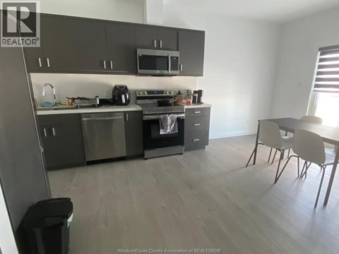 A kitchen with a dining table and chairs.