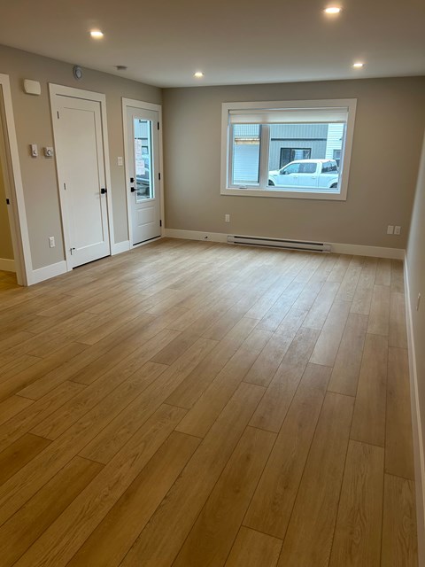A room with wooden flooring and a window.