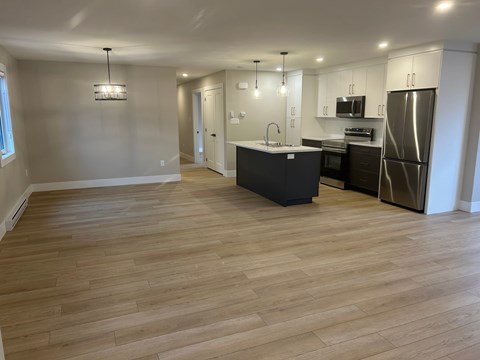 A kitchen with a black island and stainless steel appliances.