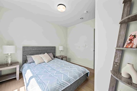 A bedroom with a large bed and a wooden shelf.