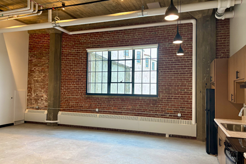 A large open space with a brick wall and a window.