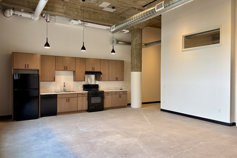 A kitchen with wooden cabinets and black appliances.