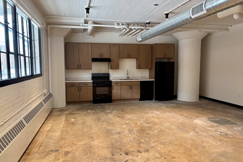 A kitchen under construction with exposed ductwork on the ceiling.