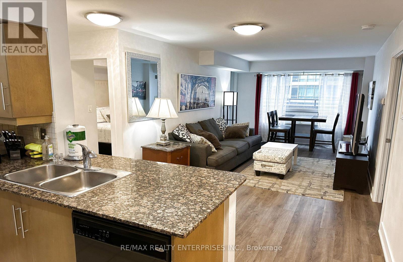 A kitchen with granite countertops and a dining area with a table and chairs.