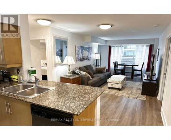 A kitchen with granite countertops and a dining area with a table and chairs.