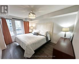 A bedroom with a large bed and a chandelier.