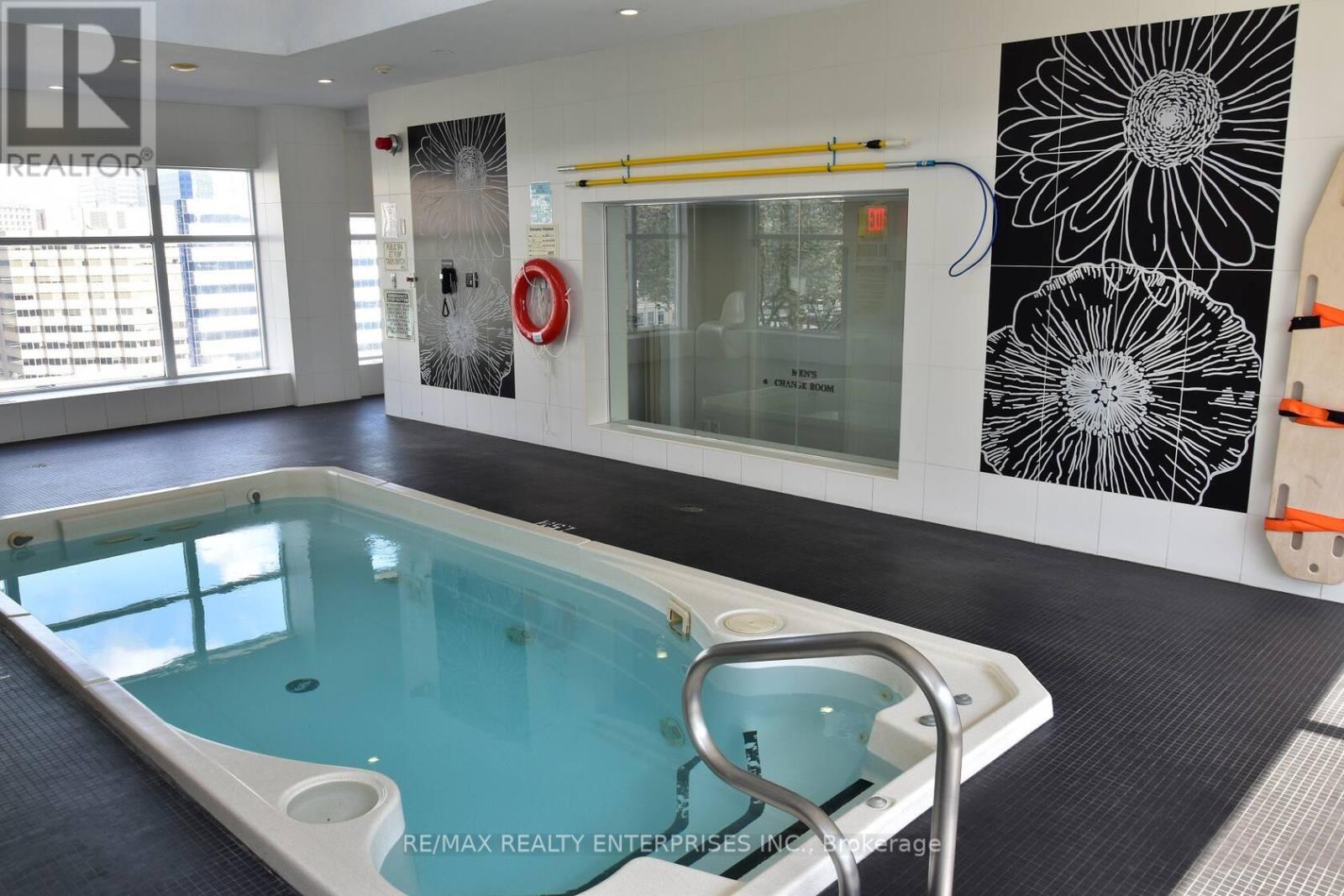 A pool in a room with a black and white flower on the wall.