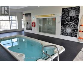 A pool in a room with a black and white flower on the wall.