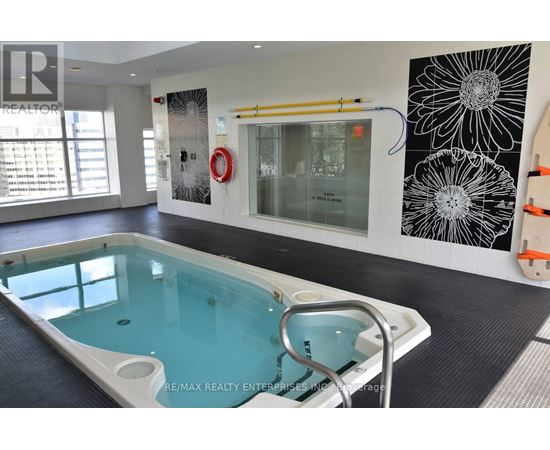 A pool in a room with a black and white flower on the wall.