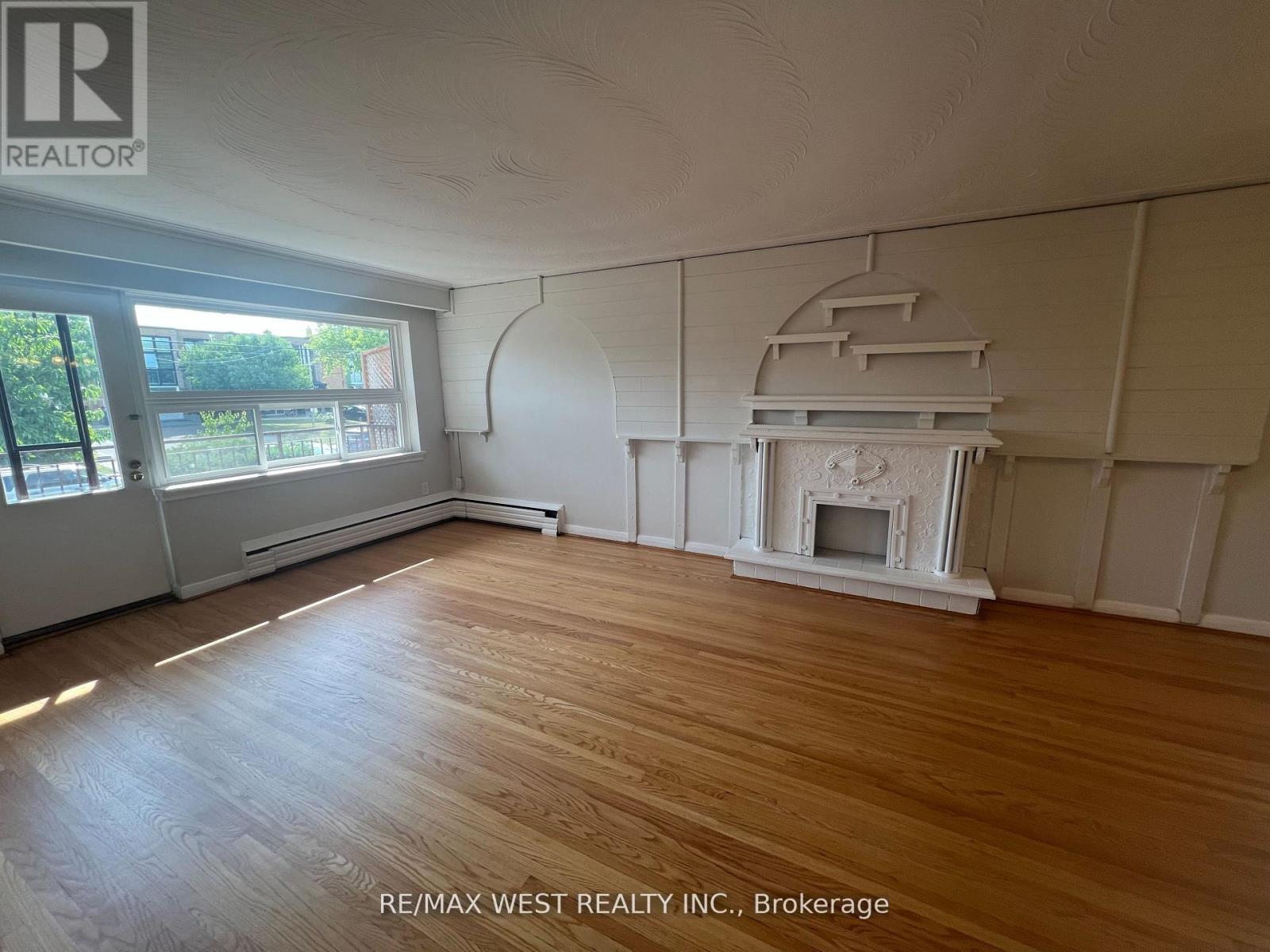 A room with a fireplace and wooden floors.