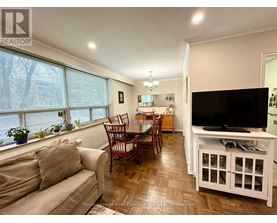 A living room with a couch, chairs, and a television.