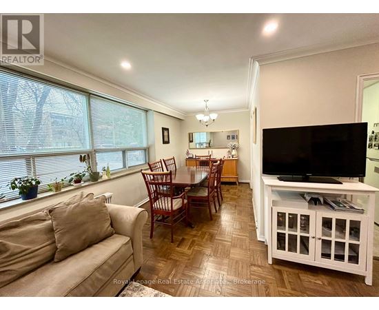 A living room with a couch, chairs, and a television.
