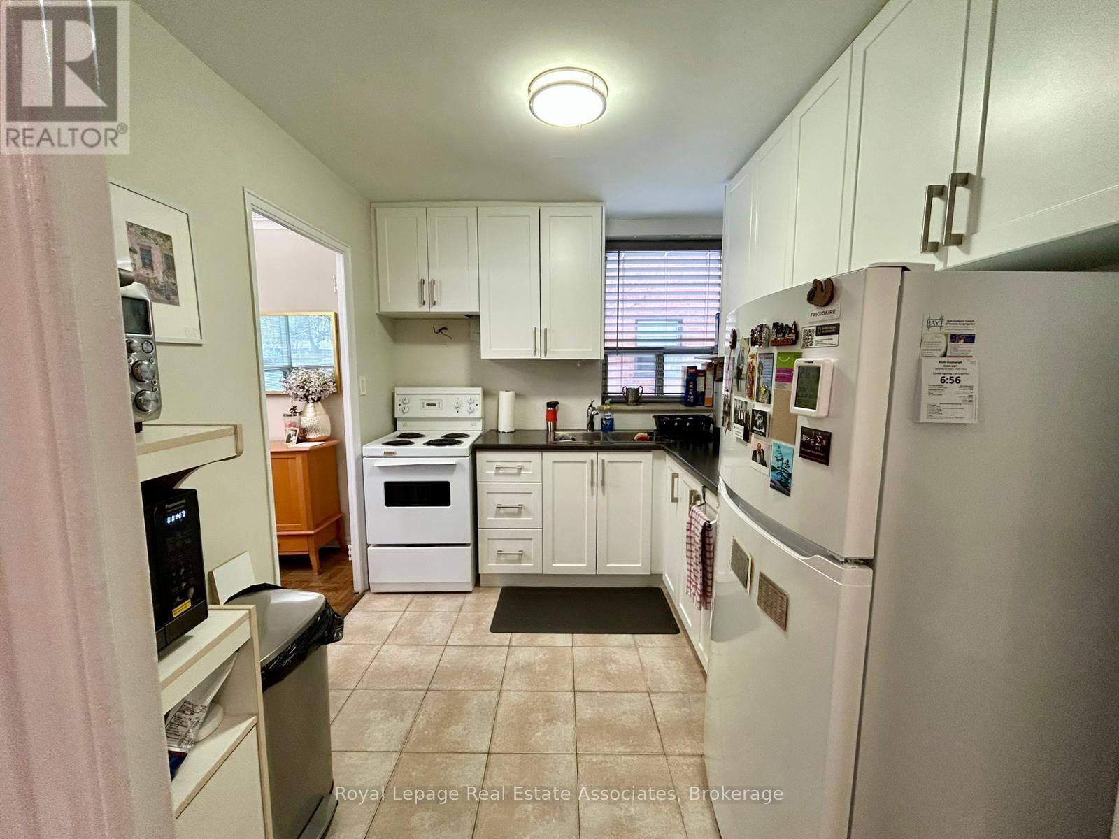 A kitchen with white appliances and cabinets.