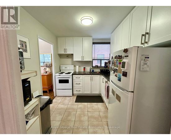 A kitchen with white appliances and cabinets.